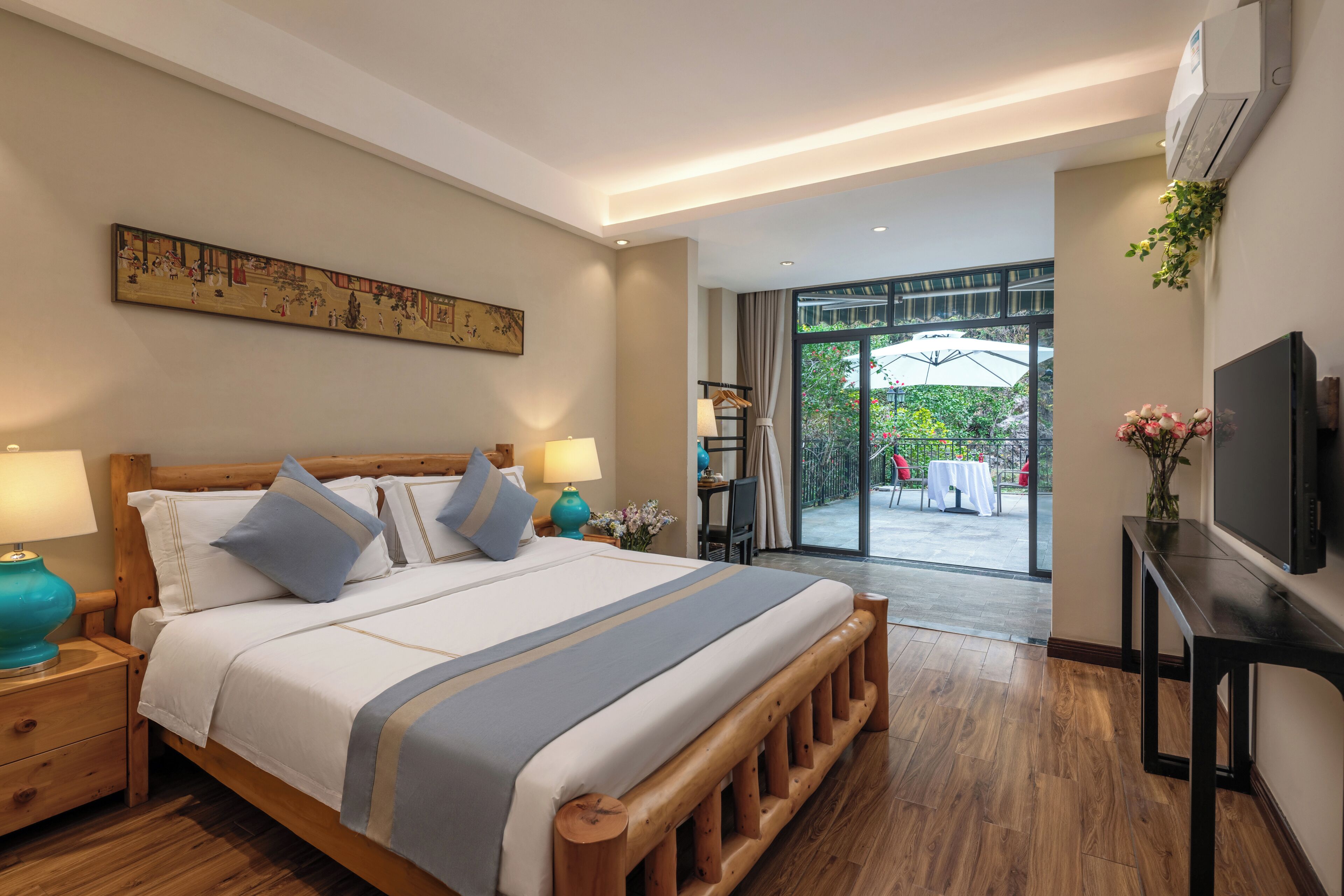 Habitación de hotel con una cama grande, televisor, escritorio y vistas al exterior.