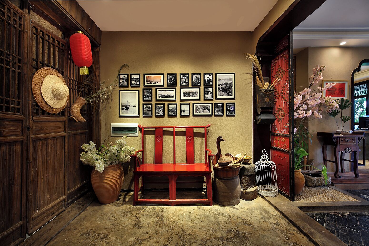 Un interior tradicional con un banco de madera, fotografías colgadas en la pared y objetos decorativos.