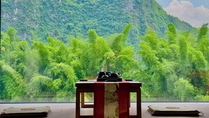 Une pièce avec une table, un luminaire suspendu et une vue sur un paysage montagneux.