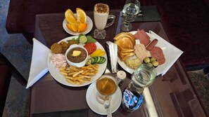 A table with a variety of food items including bread, meat, and vegetables, along with a cup of tea and a glass of milk. - Downtown Cairo Hotel (Cairo)