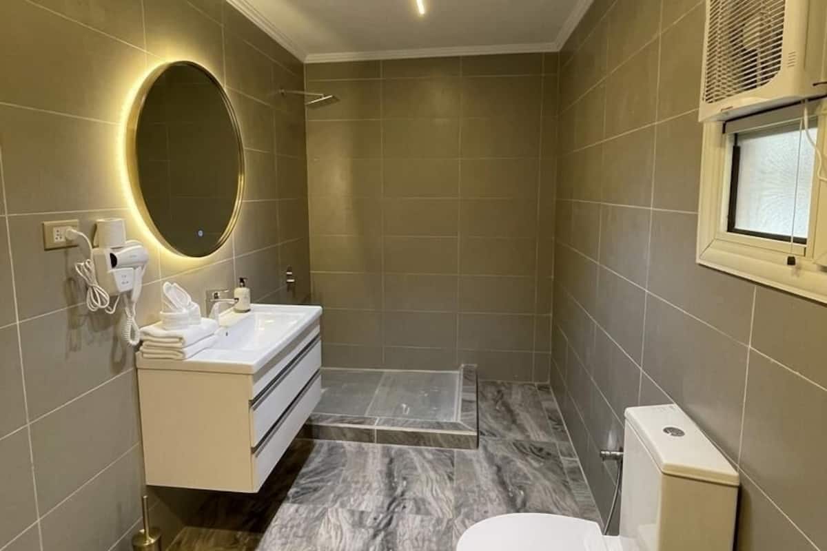Un baño moderno con tocador, inodoro y ducha.