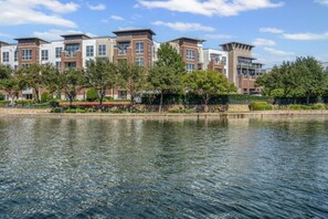 A waterfront hotel with modern architecture, a reflective pool, and a well-maintained garden. - AEA-Lake Carolyn TX (Irving)