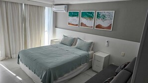 A bedroom with a bed, bedside tables, a nightstand, and a window with curtains. - Beach access | Sea view | Kitchen | WiFi | Comfort (Rio de Janeiro)