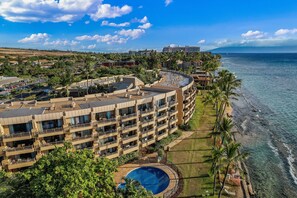 A multi-story hotel with balconies, a swimming pool, and a view of the ocean. - Ocean-view 2BR/2BA condo with pool, hot tub & beach access-Paki Maui 304 (Lahaina)