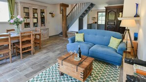 A living room with a blue sofa, wooden coffee table, and a staircase. - Lovely little house for two nestled in nature (Flayosc)