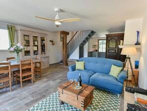 Ein Wohnzimmer mit einem blauen Sofa, einem Holztisch und einer Treppe.