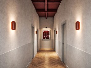 A hallway with wooden flooring, grey walls, and doors with light fixtures. - Caminetto by Interhome (Grosseto)