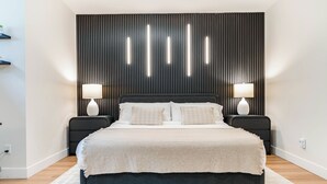 A modern bedroom with a large bed, two bedside tables, and a wall-mounted light panel. - Entire Spacious Luxury Retreat Near DT | Sleeps 4 | Fast Wifi | Free Parking (Calgary)
