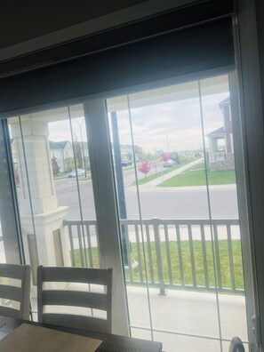 A room with a view of a street, a balcony with a railing, and a table with chairs. - Beautiful, Modren family house 5 min from airport near busstop,resturants,Malls (Calgary)