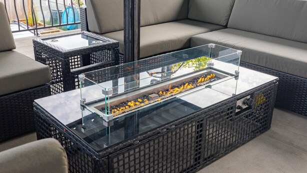 A glass-top coffee table with a decorative item inside, placed on a wicker sofa. - Vancouver Verdant Villa (Vancouver)