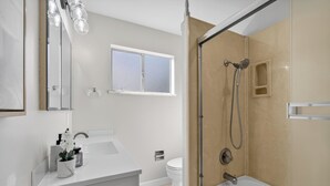 Un baño moderno con ducha, inodoro y lavamanos.