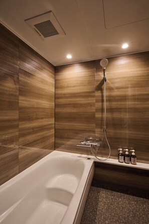 A modern bathroom with a bathtub, shower, and wooden wall paneling. - Reikyo Hanazono Osaka (Osaka)