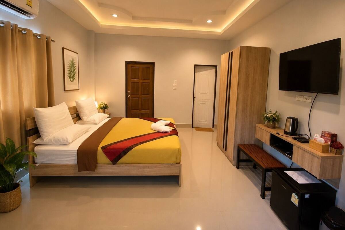 Una habitación de hotel con una cama, un televisor, un escritorio y una puerta.