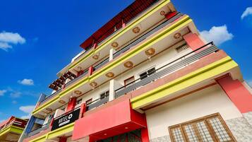 A multi-story hotel with a prominent 'HOTEL' sign, balconies, and a clear blue sky.