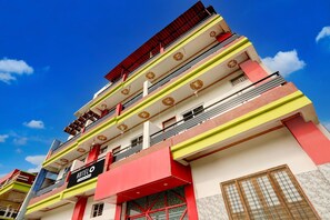 A multi-story hotel with a prominent 'HOTEL' sign, balconies, and a clear blue sky.