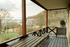 A wooden deck with a bench, overlooking a hilly landscape with trees and a distant view. - Ashiriape Toya [Log House / Lake Toya / 140inch PJ] 3 min. drive from Toya Station (虻田郡洞爺湖町清水)