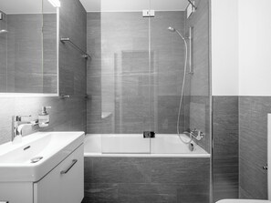 A modern bathroom with a bathtub, a sink, and a shower. - Val Signina 7-1 by Interhome (Laax)
