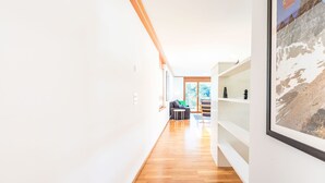 Un interno moderno con pavimento in legno, pareti bianche e un grande quadro incorniciato.