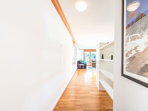 Ein modernes Interieur mit Holzboden, weißen Wänden und einem großen, gerahmten Bild.