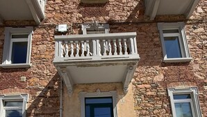 A building with a stone facade, a central entrance with a green door, and a staircase leading to the entrance. - B&B La Palma - Free Private Parking (Cuasso al Piano)
