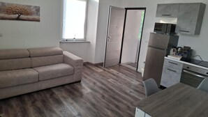 A modern kitchen with a microwave, refrigerator, and a small dining table. - B&B La Palma - Free Private Parking (Cuasso al Piano)