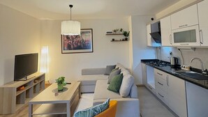 A modern living room with a sofa, TV, and dining table. - 10 Mins to Takism - Central & New Modern Flat (Beyoğlu)