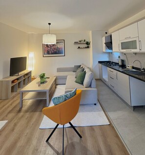 Un salon moderne avec un canapé, un téléviseur et une table à manger.