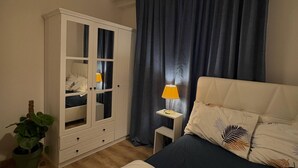 A bedroom with a bed, a wardrobe, a nightstand, a lamp, and a potted plant. - 10 Mins to Takism - Central & New Modern Flat (Beyoğlu)