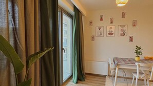A room with a dining table, chairs, a hanging light fixture, a radiator, and a window with curtains. - 10 Mins to Takism - Central & New Modern Flat (Beyoğlu)