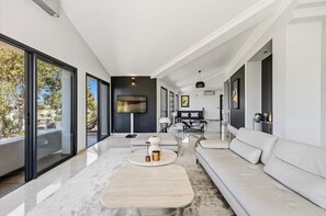 A modern living room with a sofa, coffee table, and artwork on the walls. - Magnificent 7 bedroom villa 10 minutes walk from Martinez (Cannes)