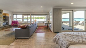 Ett modernt hotellrum med en stor säng, en soffa, en matplats och utsikt över havet.