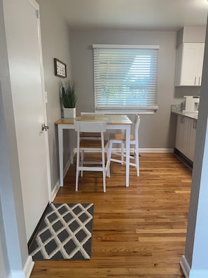 A compact kitchen with a dining table, chairs, a potted plant, and a window with blinds. - Hidden Gem close to I-5, 10 min. to downtown 2 bedroom w/AC in charming Salem OR (Salem)
