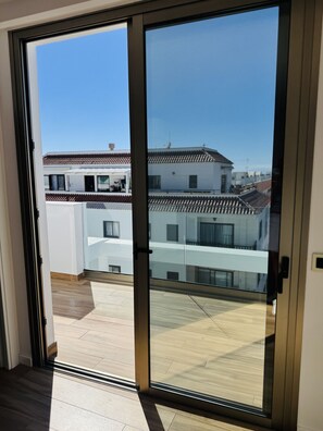 Ein modernes Interieur mit einer Schiebeglastür, die auf eine Terrassenanlage im Freien führt.