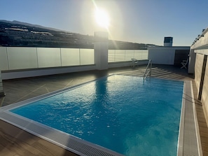 Ein Pool auf dem Dach mit freiem Blick auf die umliegende Landschaft.