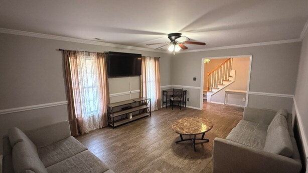 A living room with a ceiling fan, a flat-screen TV, a round coffee table, and two sofas. - Quiet Fully Furnished Comfy Home with Fast WiFi for Professionals in RTP/Durham (Durham)