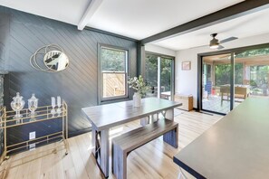 Eine moderne Küche mit dunkler Wand, Holzboden und einem großen Fenster.