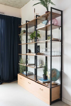 Een hoekkast met meerdere planken, lades en een wereldbol.
