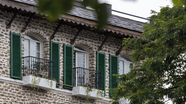 A multi-story stone building with green shutters and balconies. - Nomad Pokhara Hotel  (Pokhara)