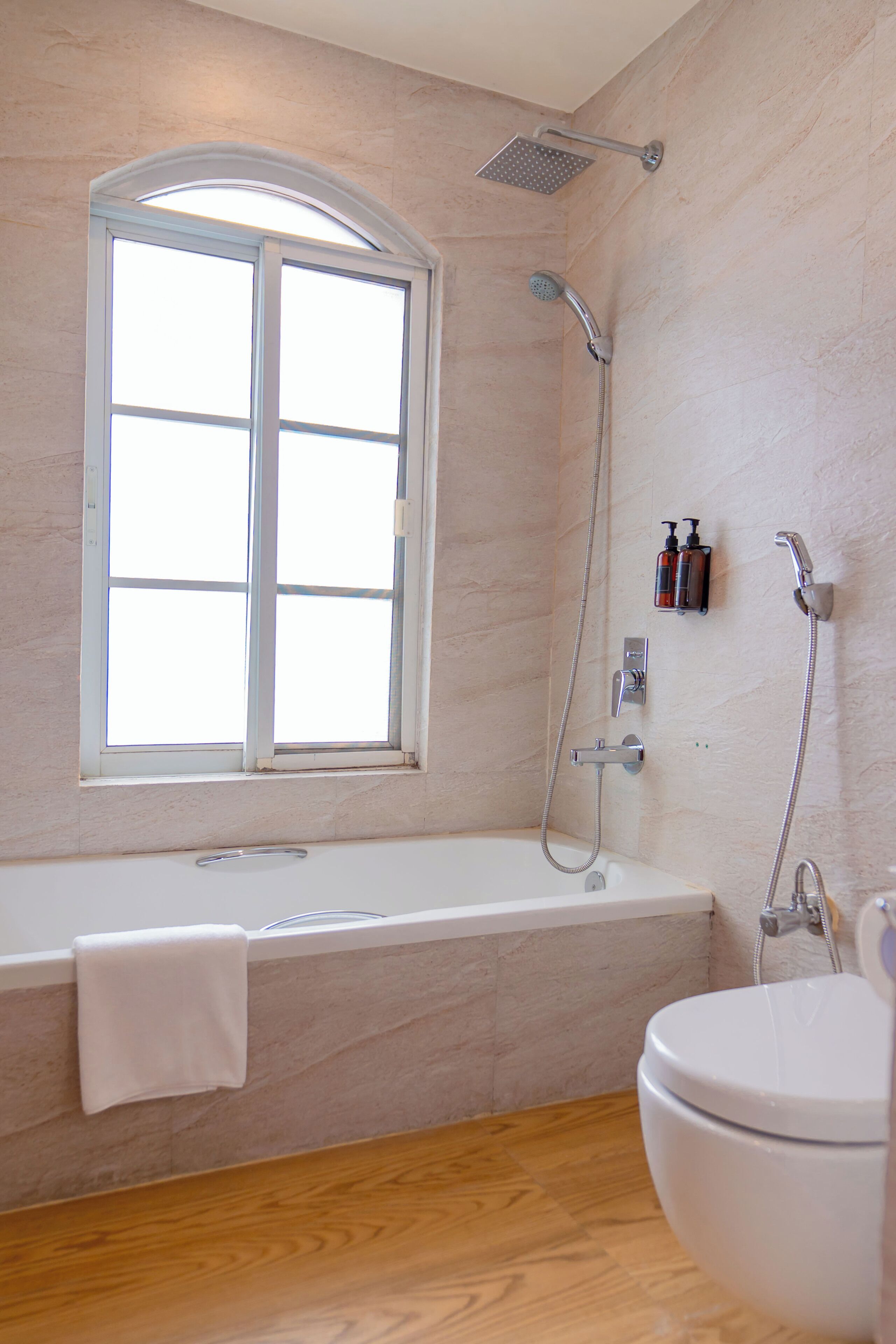 Un baño con bañera, inodoro, ducha y ventana.