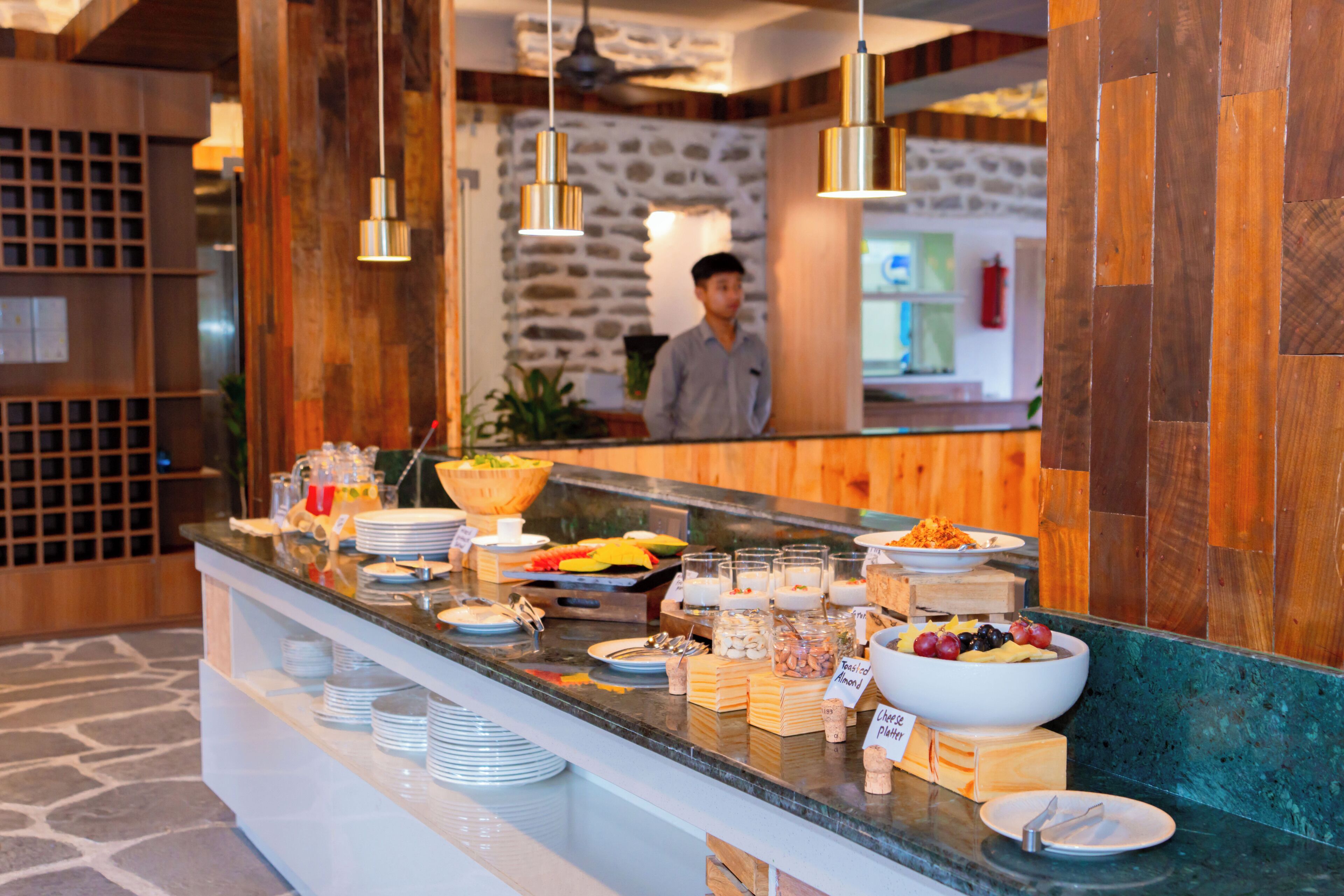A buffet counter with various food items and a person in the background.