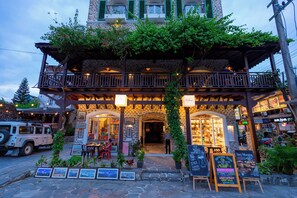 A stone building with a balcony and outdoor seating area. - Nomad Pokhara Hotel  (Pokhara)