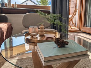 A glass table with a book, a tray, and a decorative item.