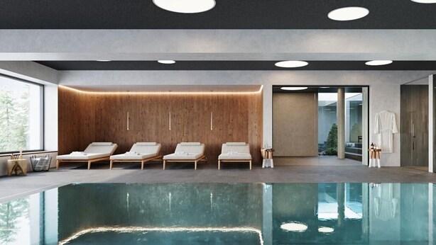 A modern indoor pool area with lounge chairs, a wooden wall, and a glass door leading outside.