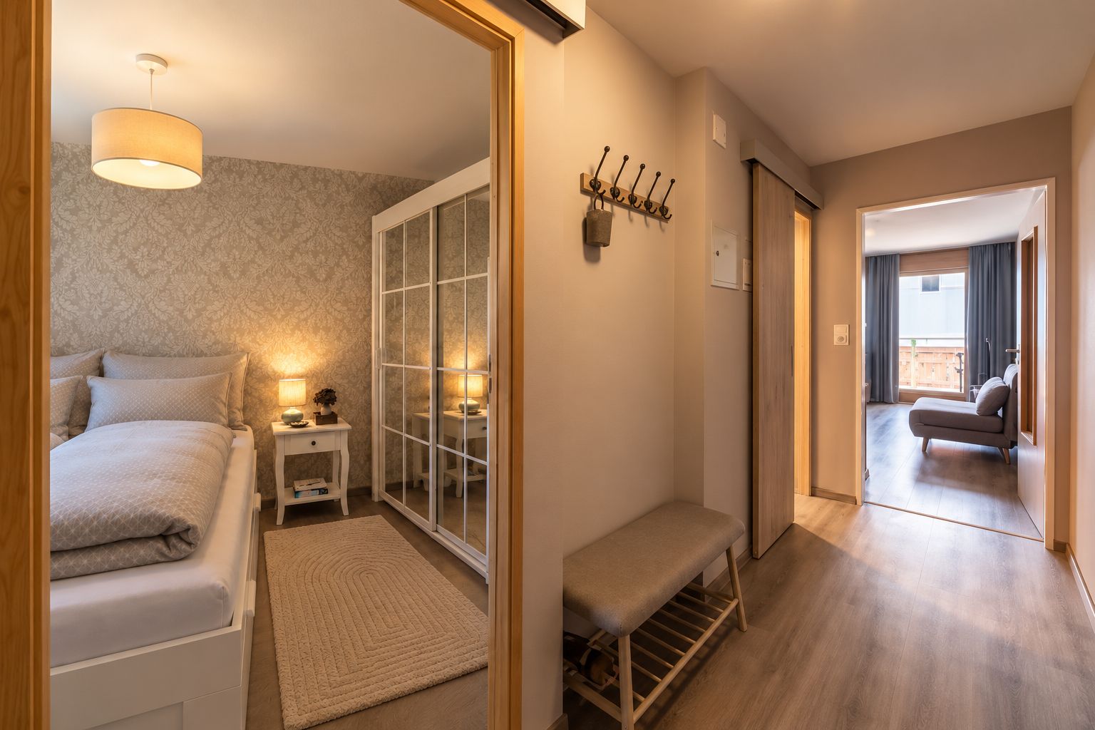 Ein Hotelzimmer mit Bett, Nachttisch, Lampe und Blick auf den Balkon.
