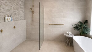 A modern bathroom with a glass-enclosed shower, a freestanding bathtub, and a small round table with a plant. - Wake to Ocean Views & Wildlife at Ohana Ocean Breeze (Penneshaw)