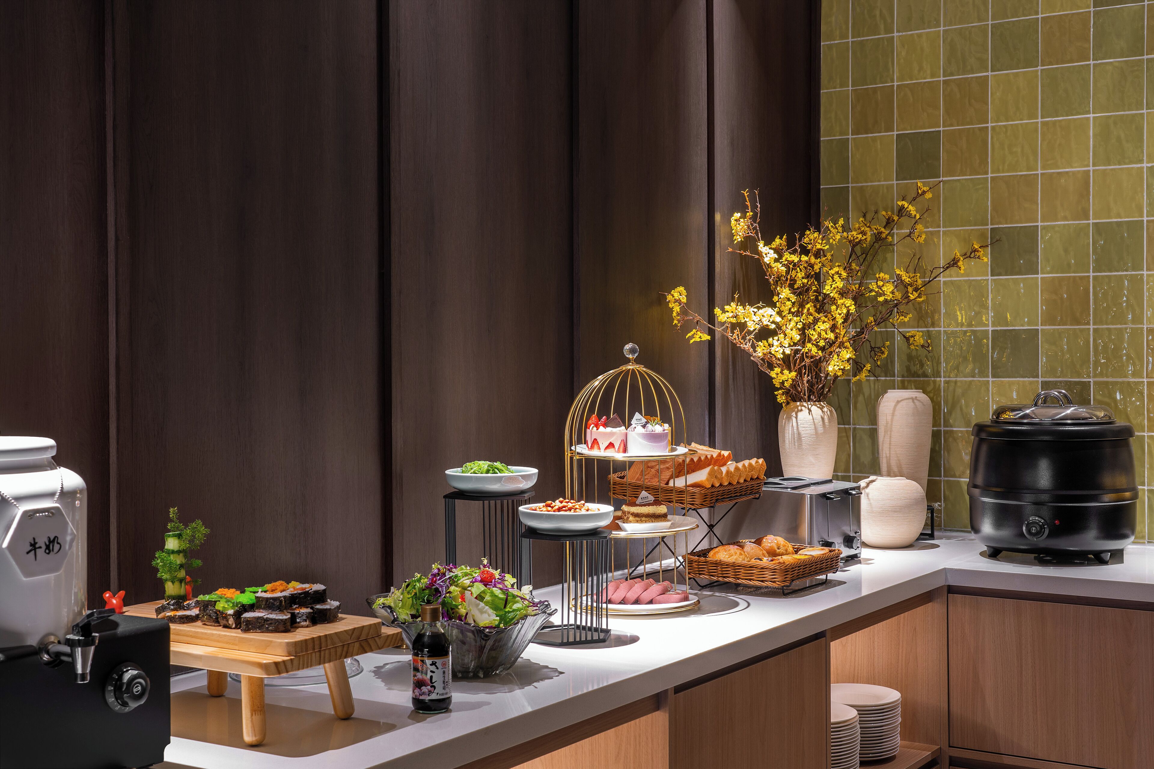 A buffet setup with various food items, a coffee machine, and a portable stove.