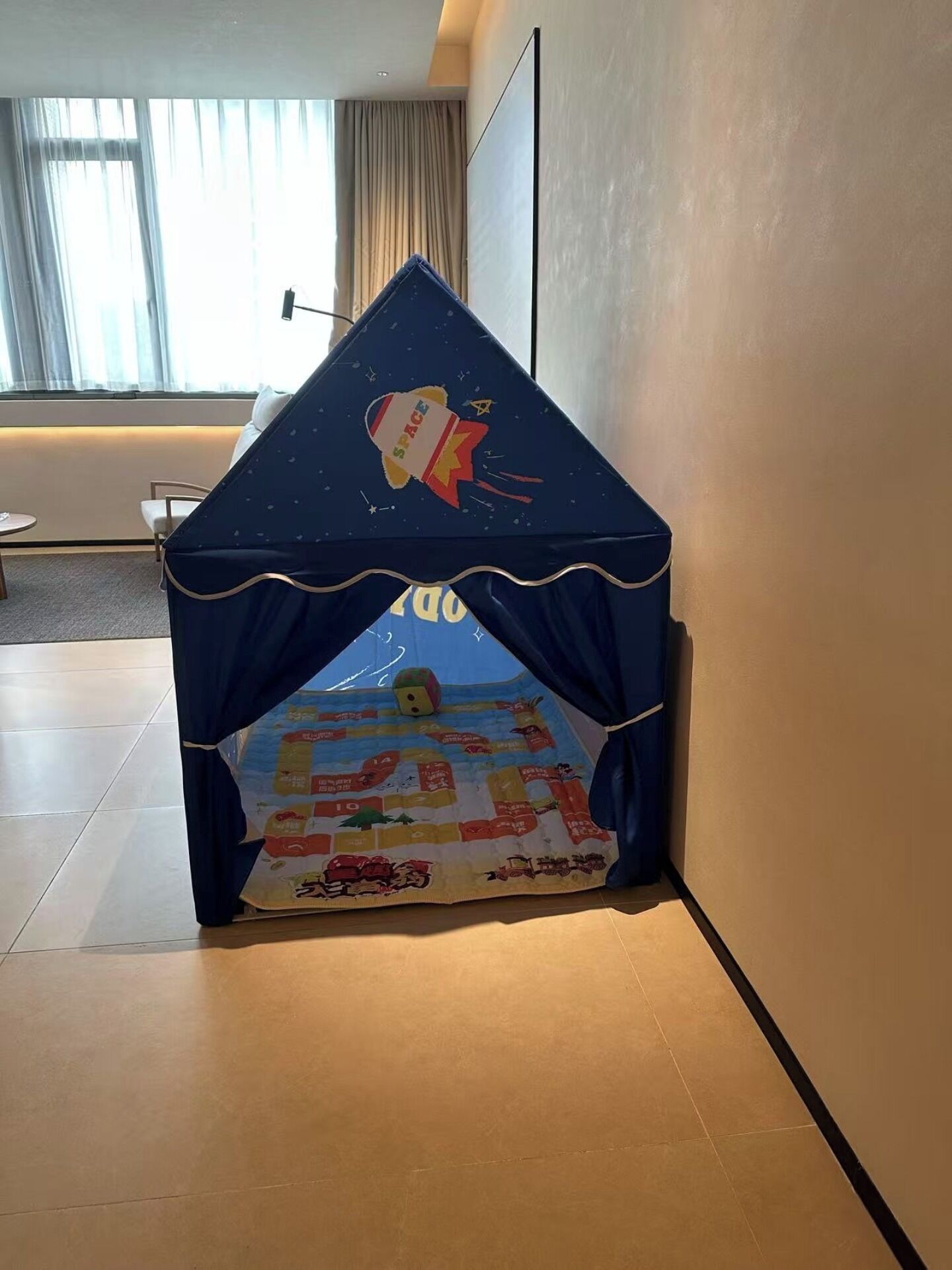 Een hoekkamer met een speeltent met ruimtevaartthema.