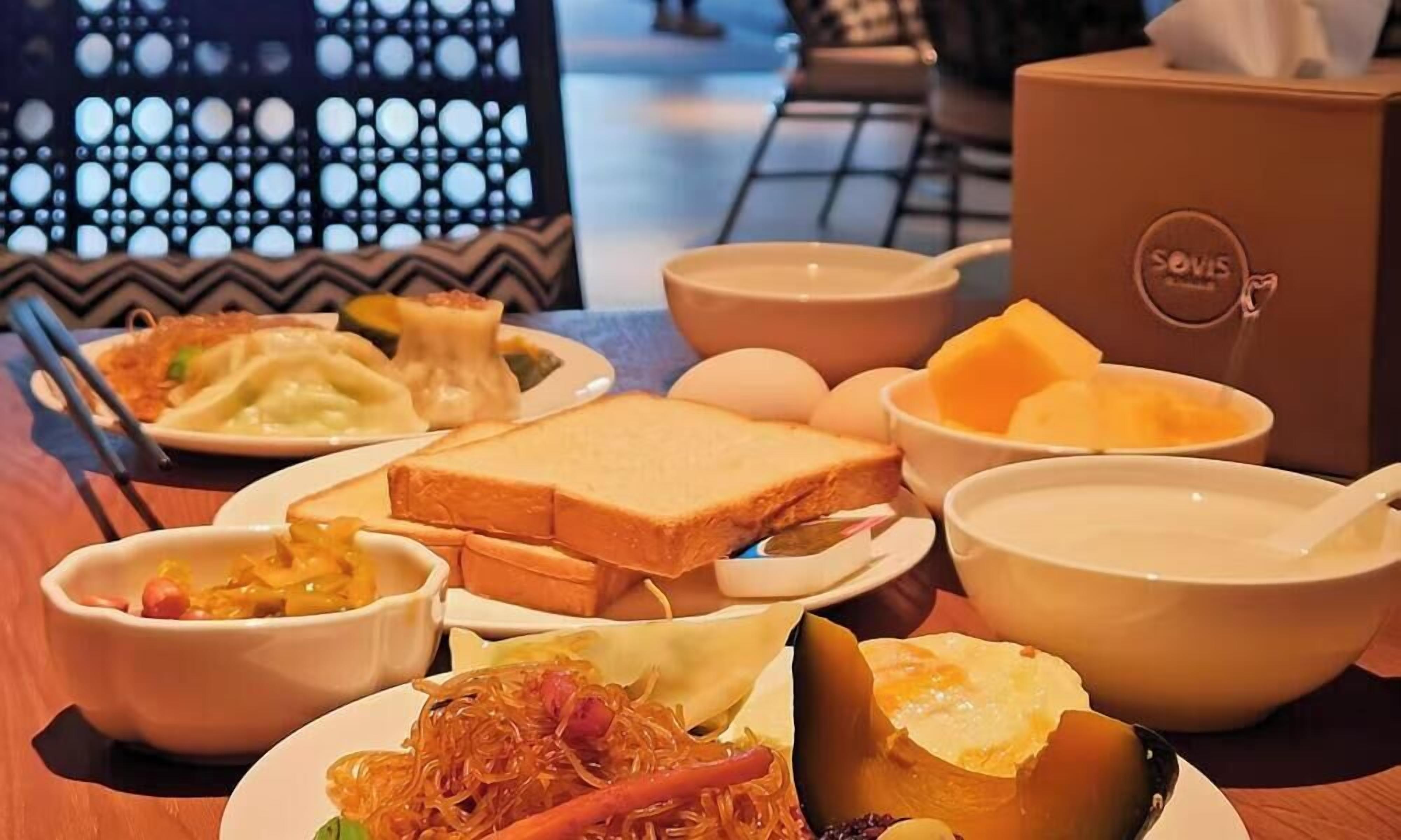 Une table où l’on trouve divers plats, notamment des raviolis, une soupe et un sandwich.