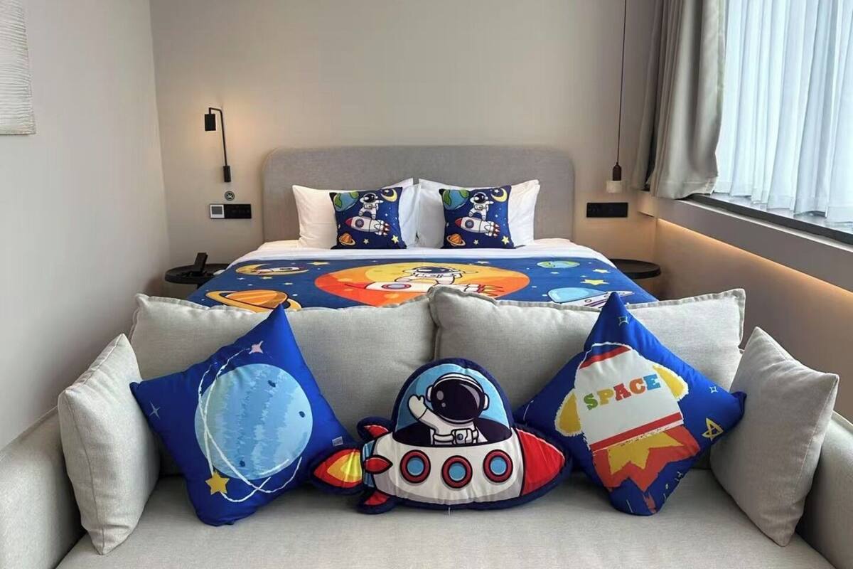 Un dormitorio con cama, sofá y ventana con cortinas.