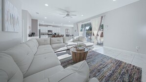 Una sala de estar moderna con un sofá modular, una mesa de centro y vistas al área de cocina y comedor.